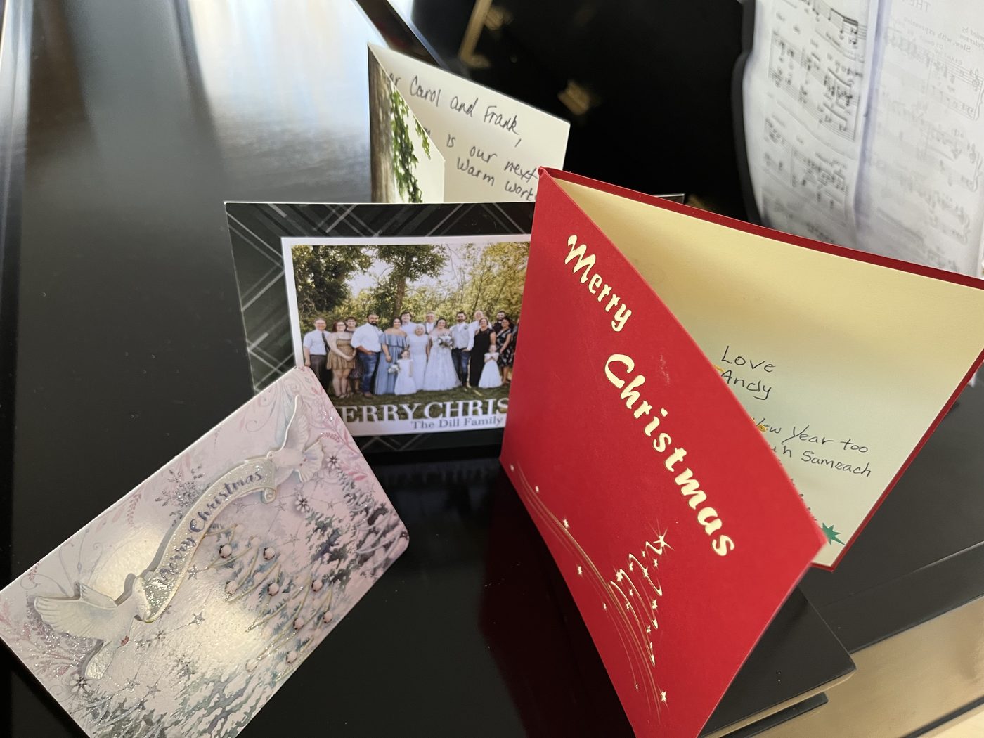 Christmas cards standing open on the lid of a grand piano
